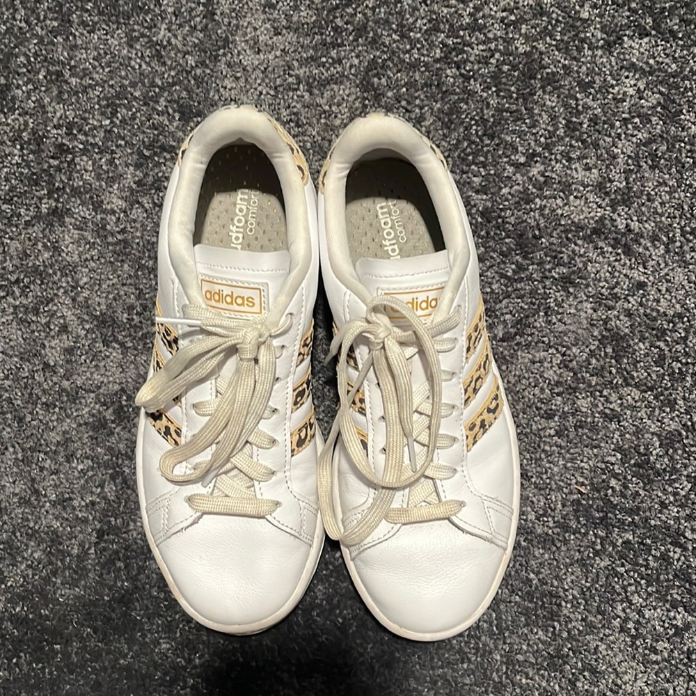 Adidas cloud foam white sneakers with leopard print logo.